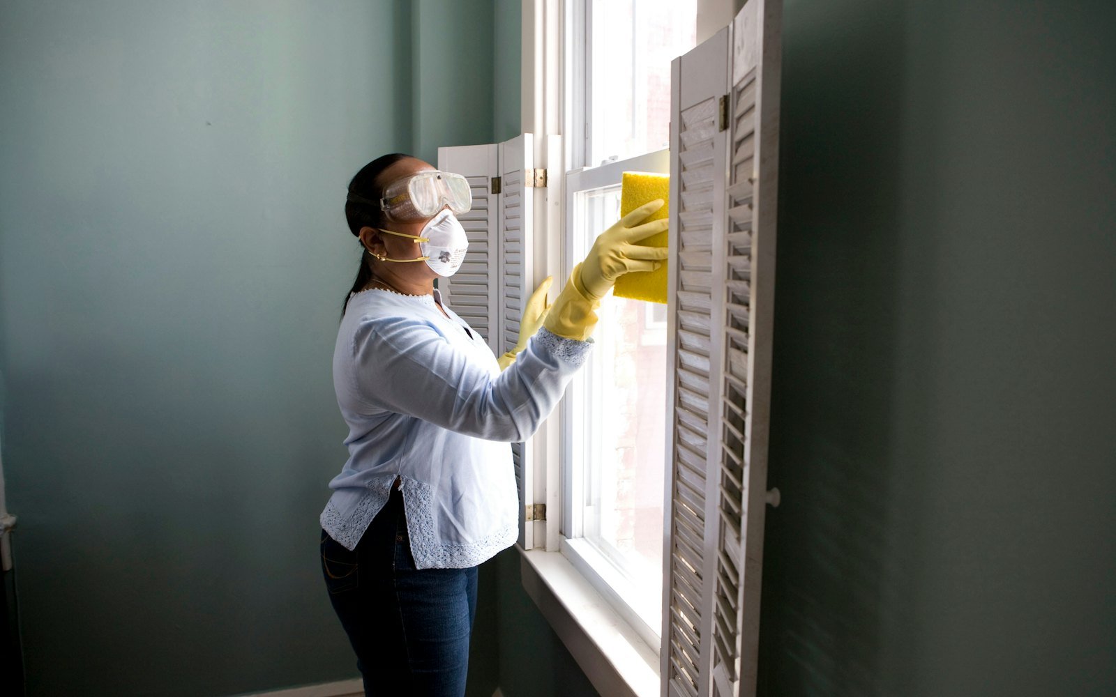 Professional cleaner wiping down a window frame